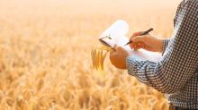 man holding farm records in grain field