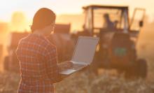 woman farmer on laptop in field