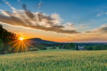 sunrise over field with mountains