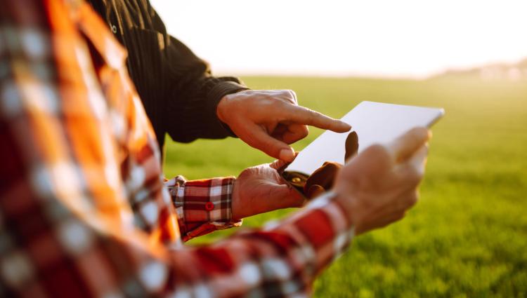 Person in field hold a ipad