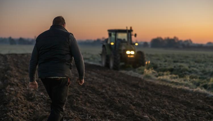 farmer at dusk with tractor
