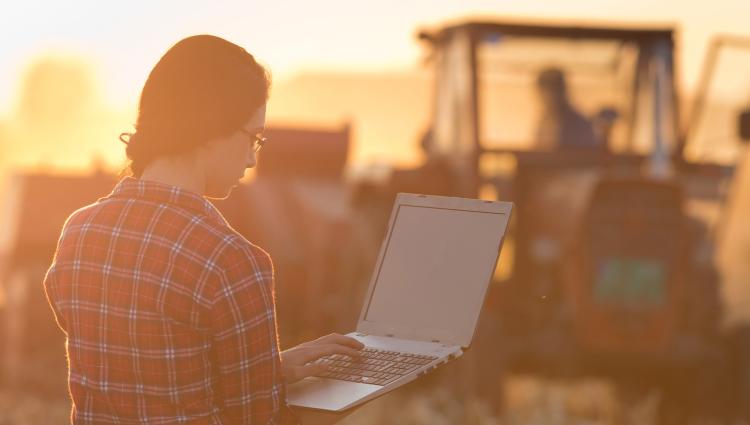 woman farmer on laptop in field